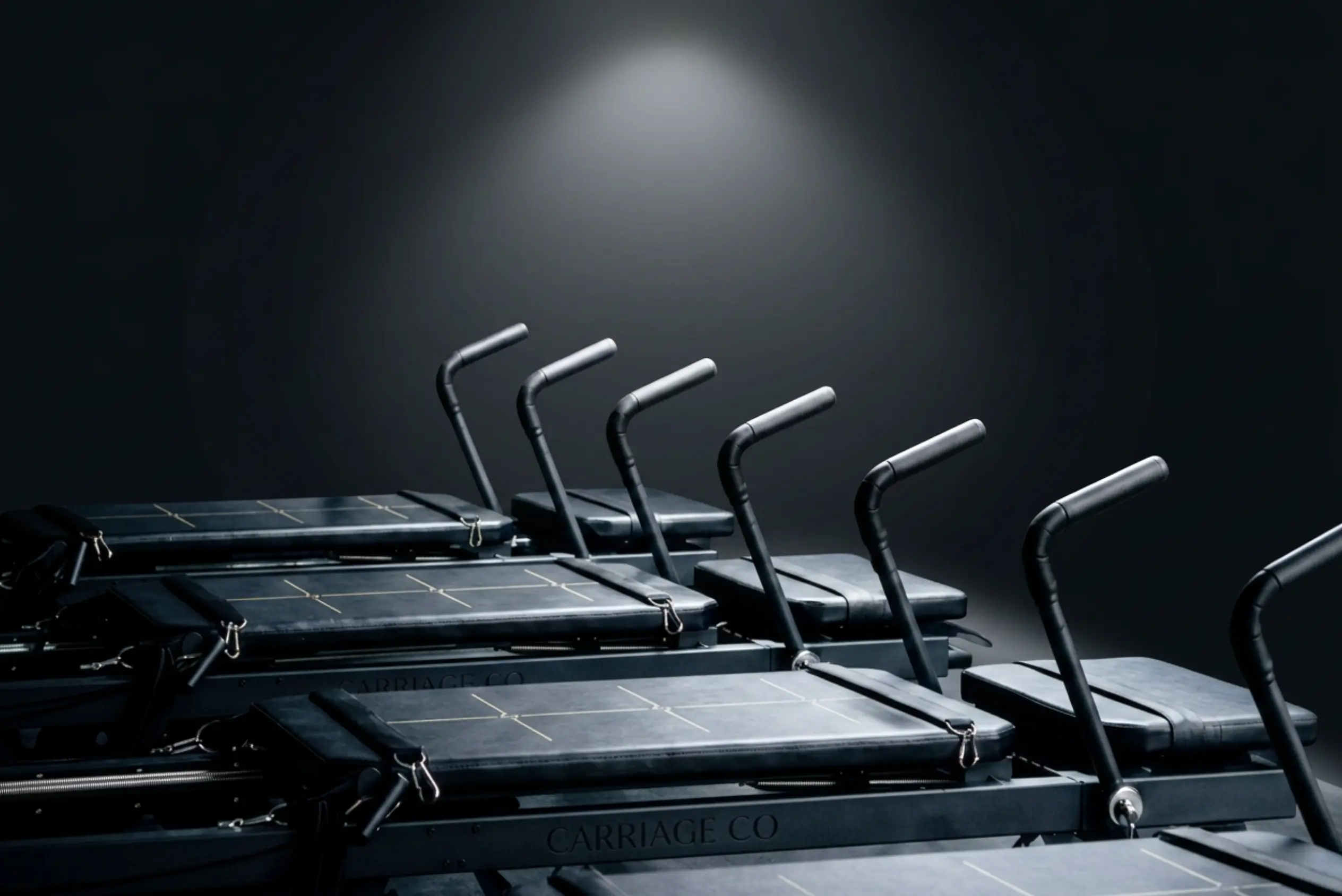 Dark studio with a row of black commercial reformers